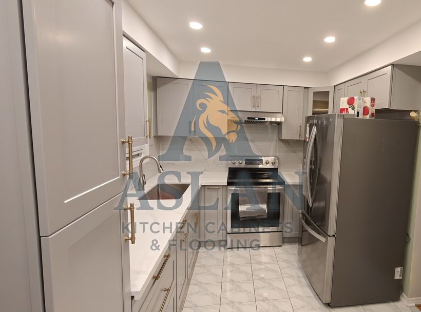 Grey L-shaped kitchen with white quartz counters and backsplash