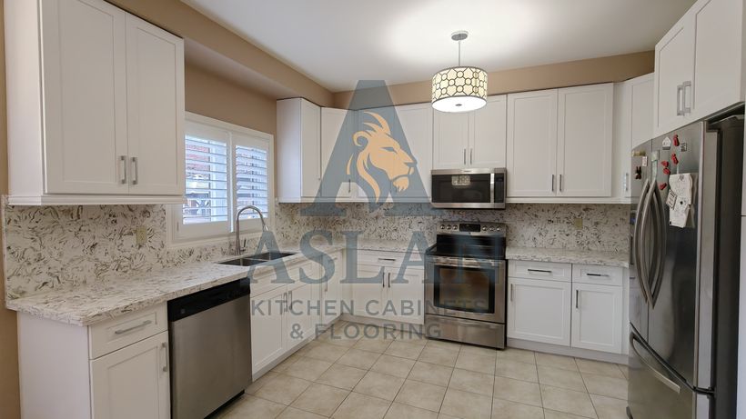 White shaker U-shaped kitchen with patterned quartz counters and backsplash