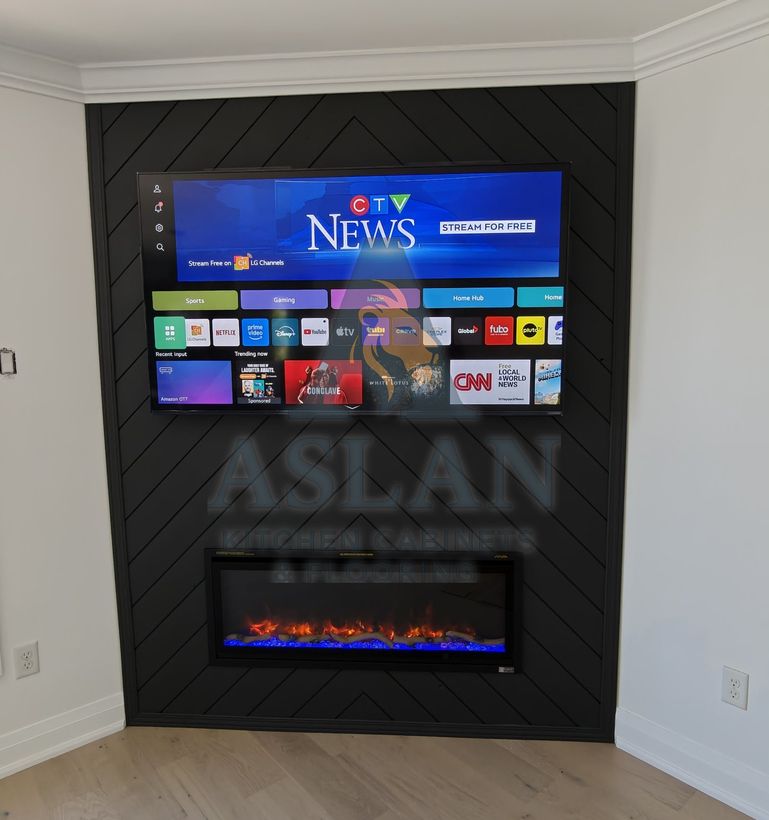 Black herringbone feature wall with a wall-mounted TV and built-in linear electric fireplace