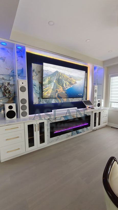 Custom white TV wall unit with marble panels, electric fireplace, glass shelves and LED lighting