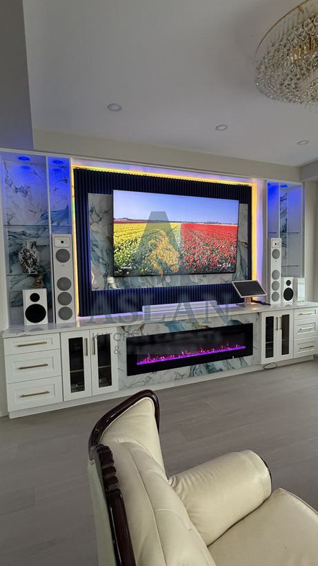 Custom built-in media wall with shaker drawers, glass doors and slatted navy panel